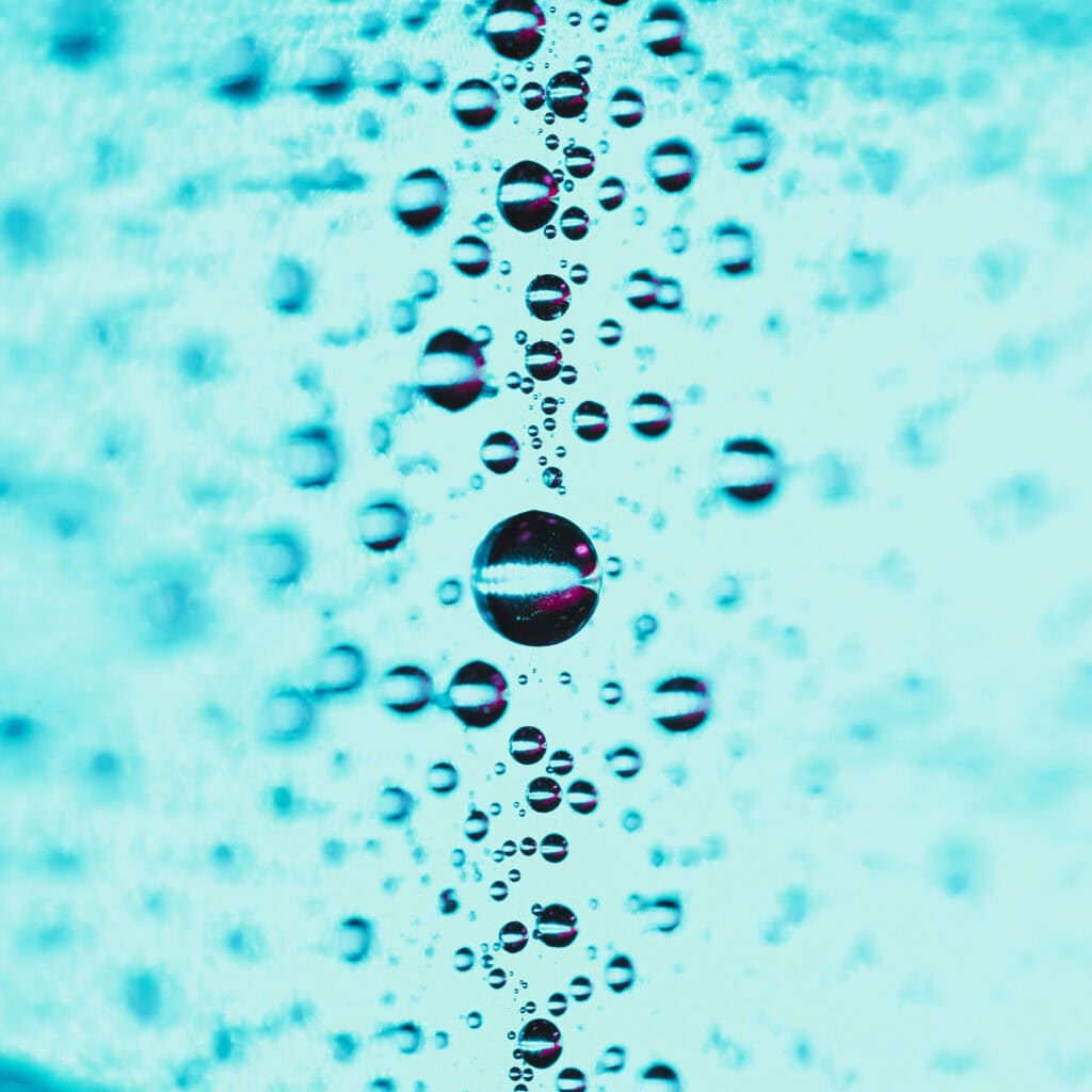 Close up of water droplets in a turquire and blurred backdrop