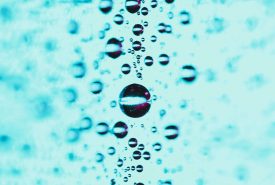 Close up of water droplets in a turquire and blurred backdrop